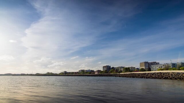 Embankment with stones passes over the Black sea against the backdrop of a sunny sky