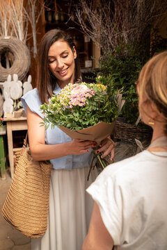 Happy customer receiving fresh flower bouquet from florist