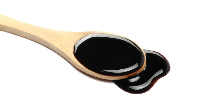 Wine vinegar in wooden spoon isolated on white background, side view