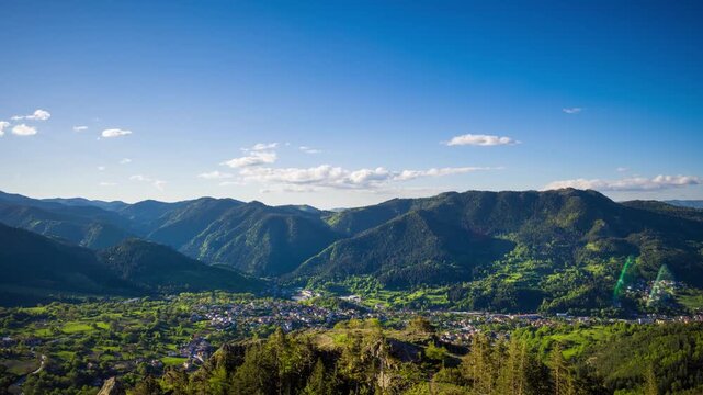 View from rock to town of Smolyan with meadows for cattle walking and houses between mountain range of Rhodope Mountains