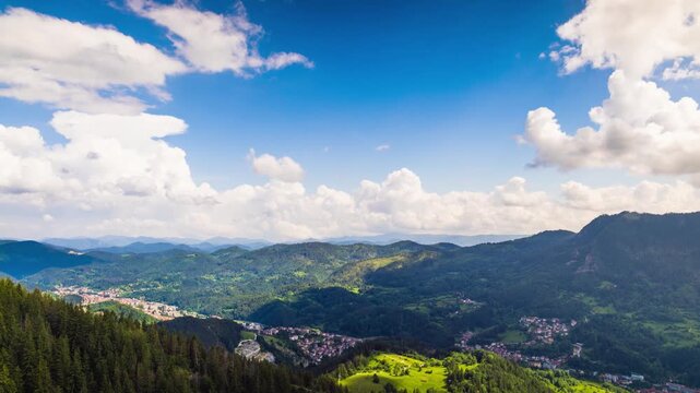 View from rock to town of Smolyan with meadows for cattle walking and houses between mountain range of Rhodope Mountains