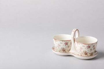 Fototapeta premium Floral tea cups on a connected tray. Space for text.