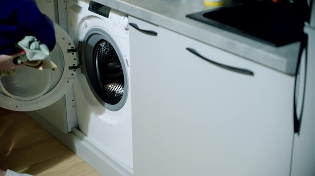 Housewife Loading Clothes Into Washing Machine. Domestic Laundry Routine. Home Appliance Chores 