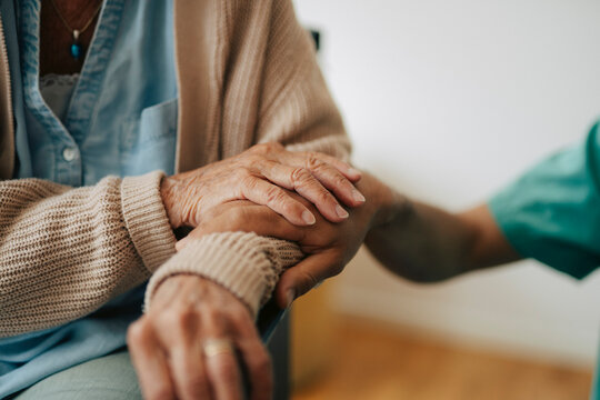 Close-up shot of nurse comforting senior patient in elder care facility