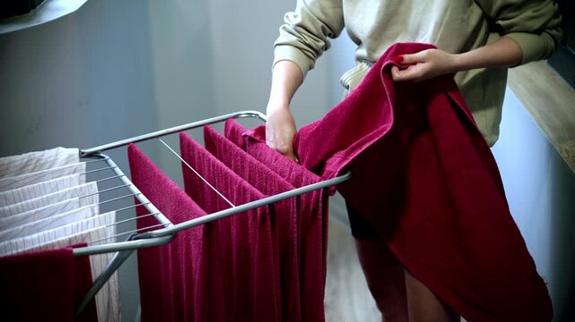 Householder Hanging Clean Towels On Clothes Drying Rack.  Domestic Laundry Chores At Home. Fresh Washed Textile Linen Care