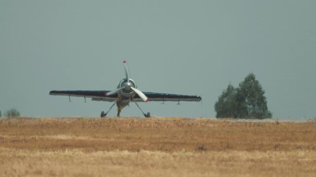 Pilot lands crop duster on field while preparing for next spraying task in agricultural area