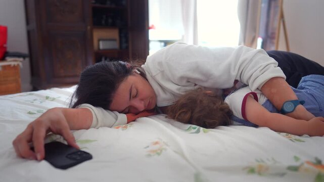 Mother sleeping beside toddler on bed at home, highlighting maternal love, secure attachment and peaceful family bonding