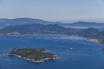 Fototapeta premium view from mount Misen of the Seto inland sea bay, with floating oyster farms beneath a blue sky and in bright sunshine