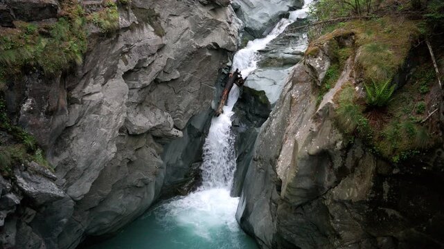 Powerful turquoise glacial water cascading through a narrow rocky gorge in the swiss alps near zermatt