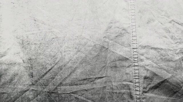 macro stitched seam on textured gray wrinkled linen fabric creates minimalist monochrome background