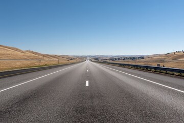 Obraz premium Deserted four lane interstate highway under a clear blue sky