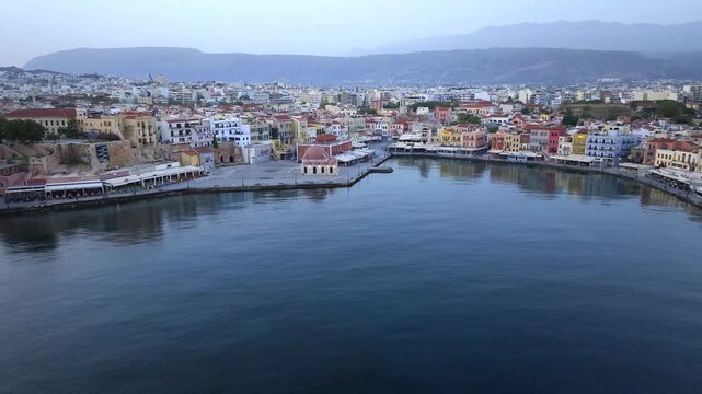  View of Chania with the amazing lighthouse, mosque, venetian shipyards, Crete, Greece.Waves crashing on lighthouse, Beautiful Greece and best scenic places - panorama