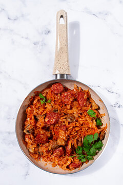 Bigos, Polish dish bigos, on the table, pan with stewed meat, with cabbage, chorizo sausages, mushrooms, homemade, without people,