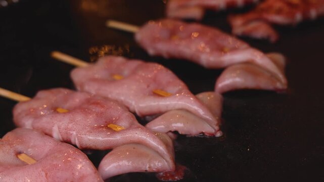 Ikayaki, Grilled roasted Squid with sauce - popular Japanese Street Food, variety of different traditional food snack selection in Tokyo, Japan, street market with local vendor stalls cooking