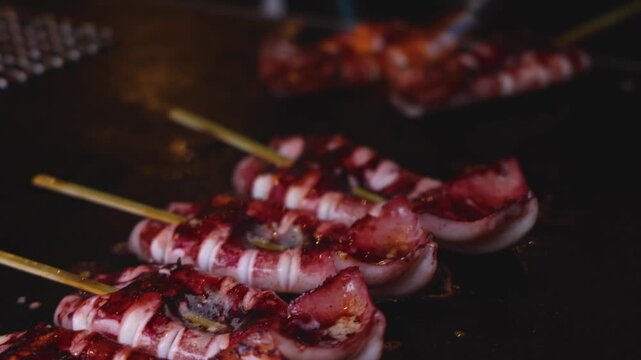Ikayaki, Grilled roasted Squid with sauce - popular Japanese Street Food, variety of different traditional food snack selection in Tokyo, Japan, street market with local vendor stalls cooking