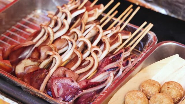 Ikayaki, Grilled roasted Squid with sauce - popular Japanese Street Food, variety of different traditional food snack selection in Tokyo, Japan, street market with local vendor stalls cooking