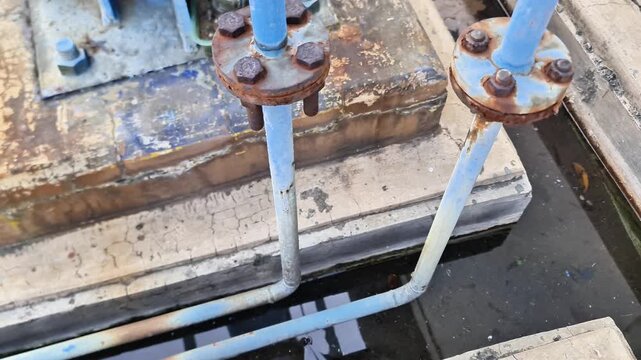 Rusty flanged pipe connections and corroded bolts on blue industrial pipeline highlighting maintenance needs