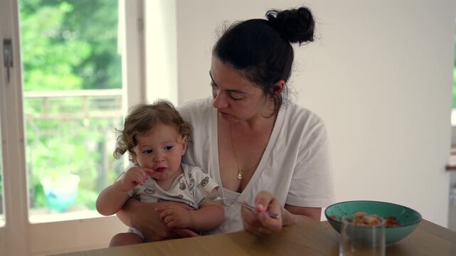 Mother struggling to feed reluctant toddler during mealtime, highlighting picky eating, gentle parenting and everyday family life