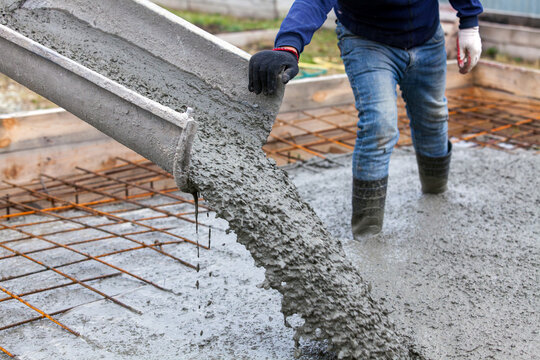 Closeup shot of concrete casting on reinforcing metal bars of floor in industrial construction site