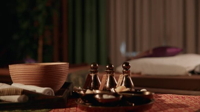 Slow motion close up of Thai relax Oil spa accessories on massage table in wellness room with soft focus.