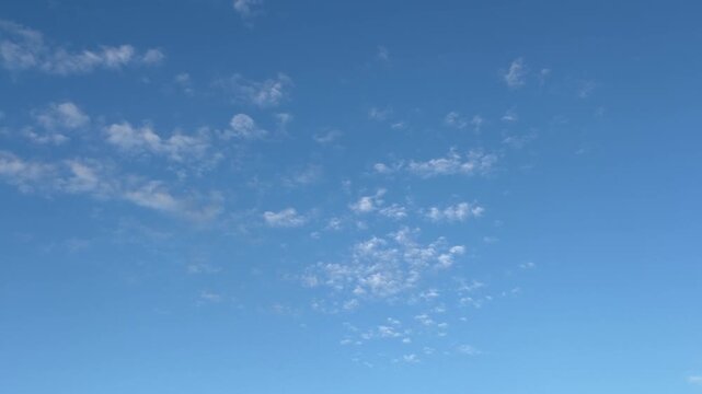 Wide blue sky time lapse with small cloud dissolving over clean horizon