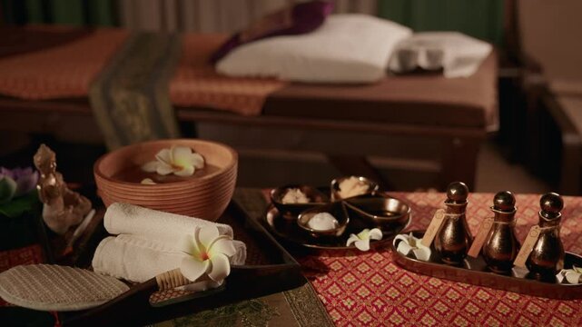 Spa accessories and massage bowl on treatment table in wellness room, Thai relax Oil.
