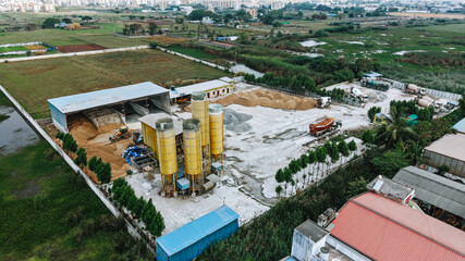 Fototapeta premium Top down aerial of sand and cement stacks at an active construction materials facility