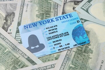 Fototapeta premium Driver's licence on dollar banknotes as background, closeup
