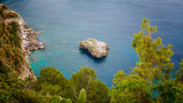 Rocky coastline of Capri Island with crystal-clear turquoise water, breathtaking Mediterranean seascape, dramatic cliffs and pristine coastal landscape in Italy