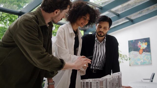Multiracial team of architects discusses house innovative design