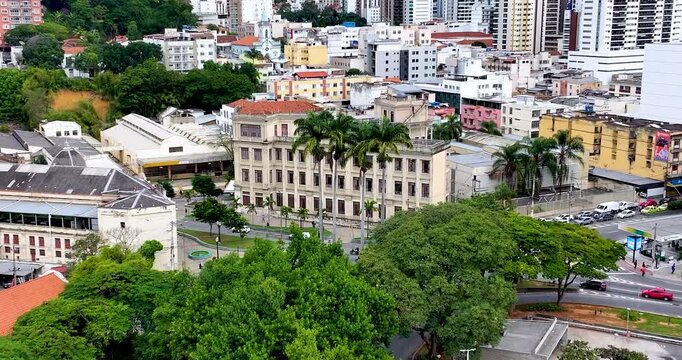 4K drone aerial view of Escola Normal in downtown Juiz de Fora, Minas Gerais, Brazil, surrounded by historic buildings and urban skyline.