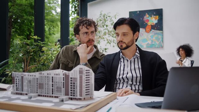 Architects study design plans for modern apartment complex
