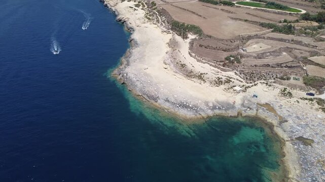 Ras il-Hobz salt pans, aerial shot , Gozo, Malta. serene aerial view of a coastal landscape with water and land, featuring blue and green hues and natural vegetation. High quality 4k footage