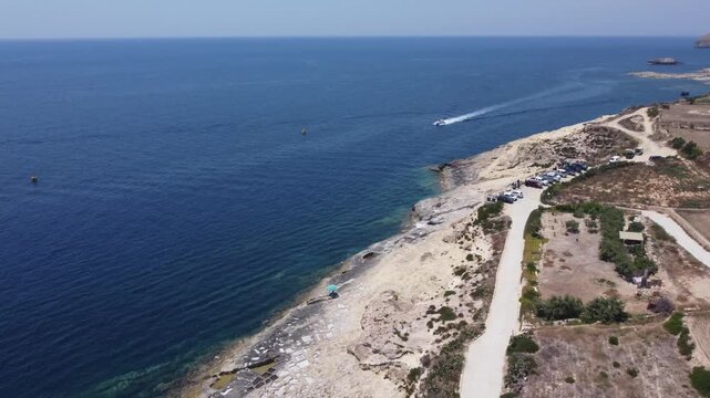 Ras il-Hobz salt pans, aerial shot , Gozo, Malta. serene aerial view of a coastal landscape with water and land, featuring blue and green hues and natural vegetation. High quality 4k footage