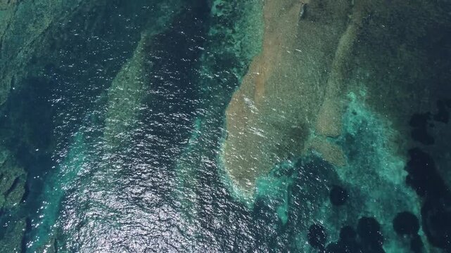 Ras il-Hobz salt pans, aerial shot , Gozo, Malta. serene aerial view of a coastal landscape with water and land, featuring blue and green hues and natural vegetation. High quality 4k footage