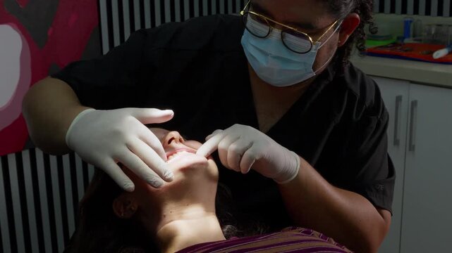 Male orthodontist placing clear aligners on woman's teeth