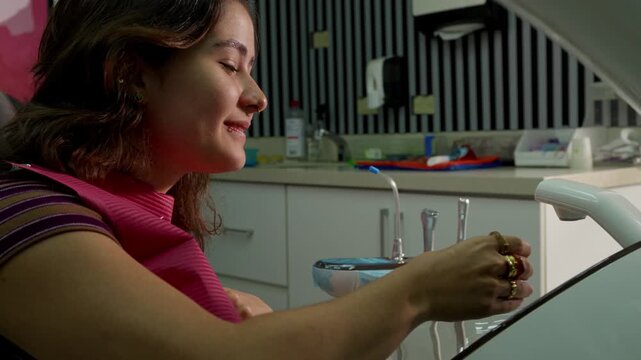 Female patient rinsing mouth at the dentist office