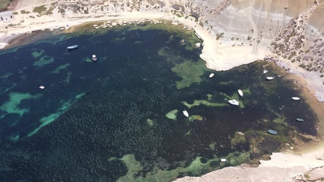 Steep Clay Cliffs in Gozo Malta During Sunny Weather Featuring Earthy Tones and Deep Blue Sea, aerial view near Xatt L-Ahmar salt pans. High quality 4k footage