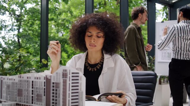 Woman architect analyzes facade and proportions of scale model