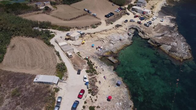 Xatt L-Ahmar, Gozo, Malta. Salt apns. serene aerial view of rocky coastline with sandy beaches and calm waters in natural setting for travel and vacation purposes. stationery perspective from above