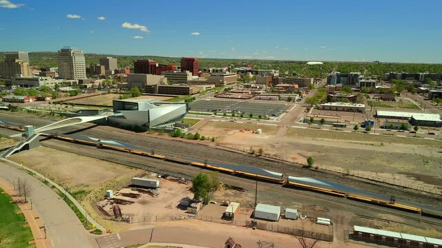 High overhead drone shot of freight train carrying oversized wind turbine blades through Colorado