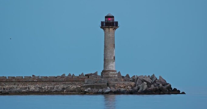 Full strawberry moon rising behind Trakata coastal lighthouse near Euxinograd beach in Varna Bulgaria