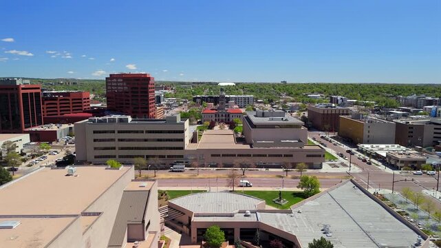 Drone approaching historic courthouse with clock tower set in Colorado Springs downtown district