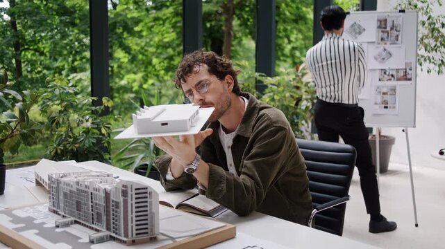 Attentive engineer observes building miniature model in office