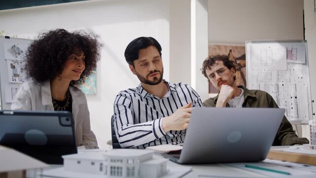 Engineer shows innovative building model to colleagues in office