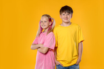 Fototapeta premium Portrait of brother and sister on orange background