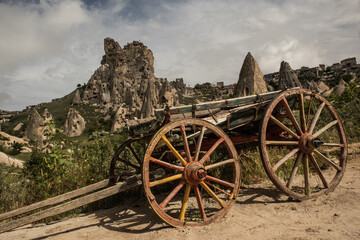 Obraz premium Old Wooden Cart on Dirt Road in Front of a Dramatic Volcano Rock Valley
