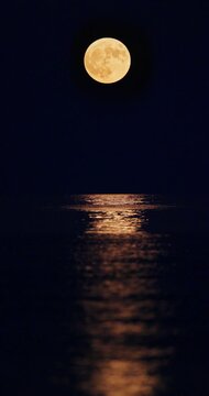 Full strawberry moon with bright moonpath reflection on sea water at night beautiful landscape