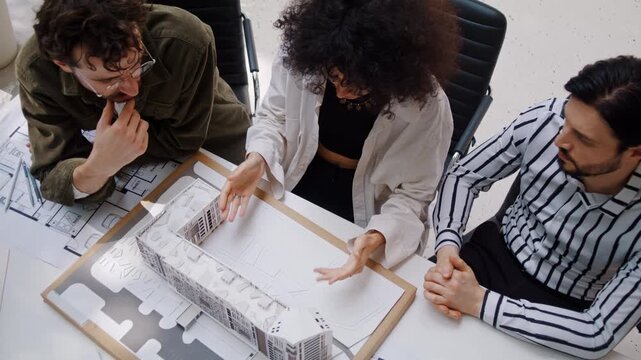 African American designer presents building model to colleagues