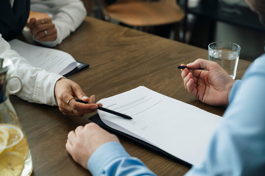 Female business professional showing showing signature line on contract to client